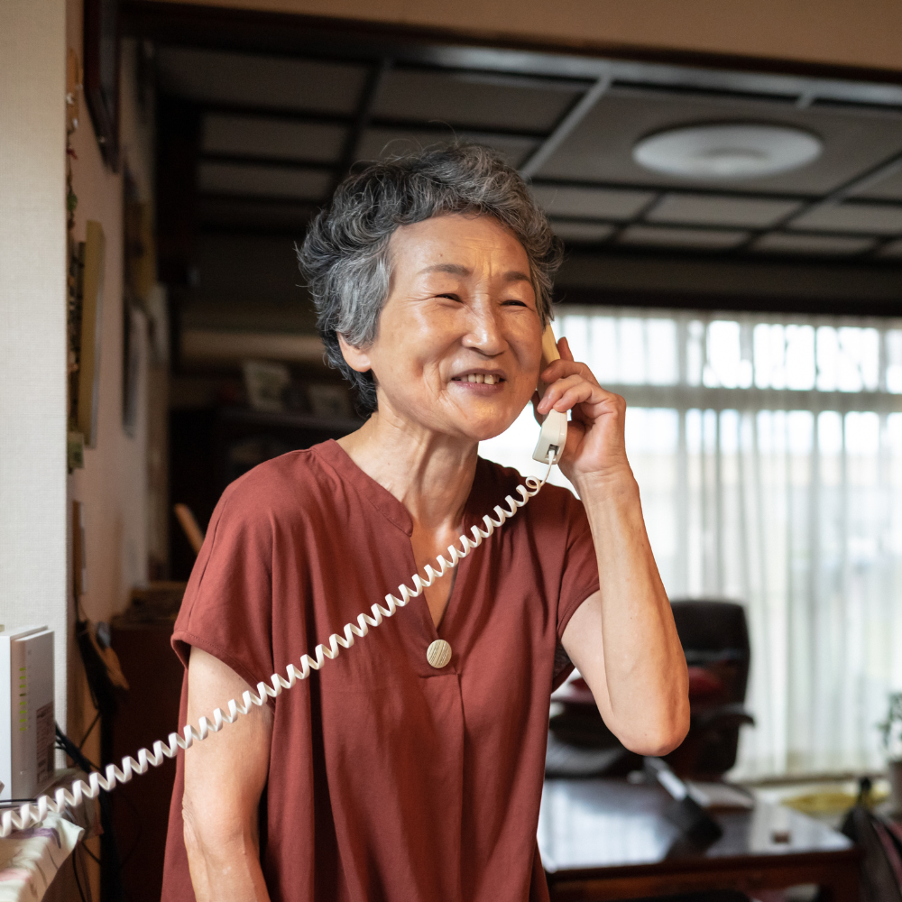 Lady having a conversation on a corded telephone
