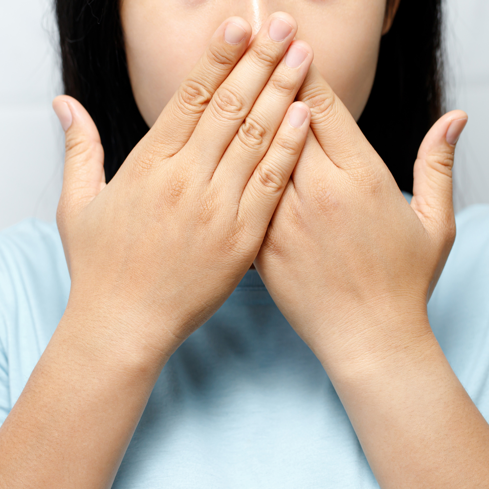 Lady covering her mouth with both her hands