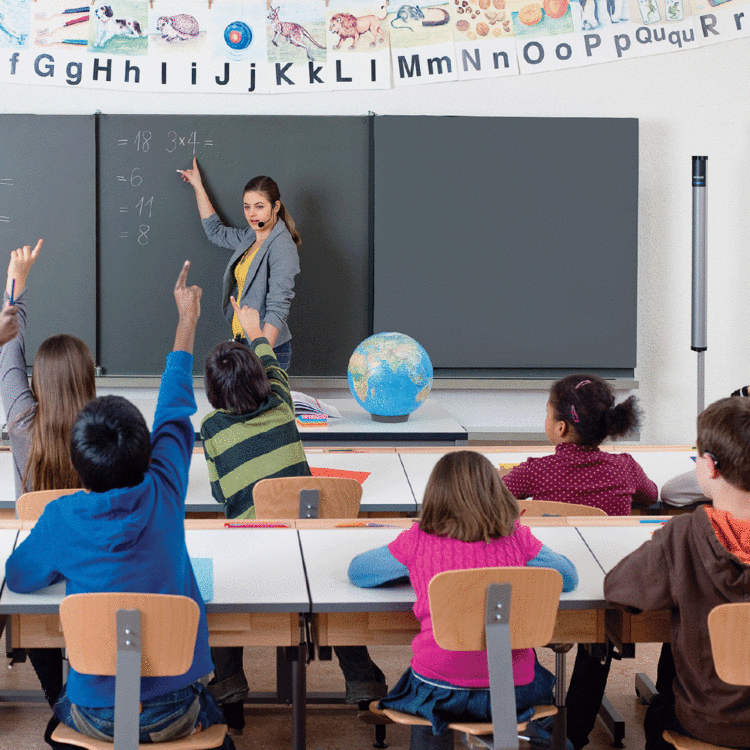 teacher and students in a classroom in front of a blackboard with the digimaster speakers