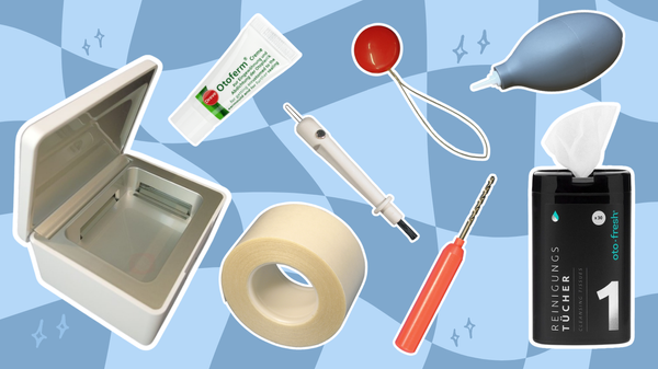 Flat lay of hearing aid accessories including drying box and various cleaning tools