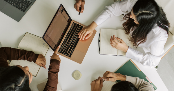 Corporate meeting at a table with laptop and phonak roger table mic 